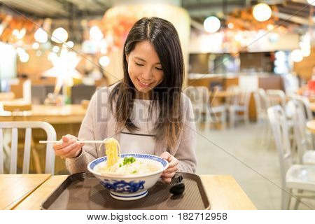 Woman enjoy her japanese noodles in restaurant