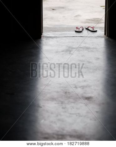 COLOR PHOTO OF PAIR OF FLIP FLOPS ON CONCRETE GROUND