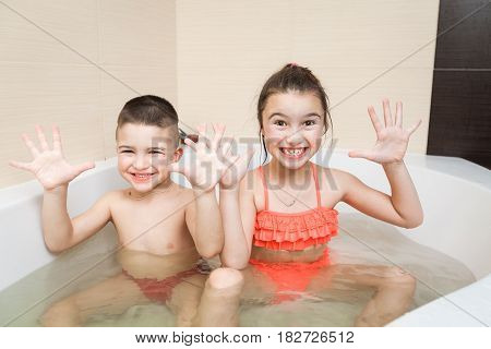 Happy smiling brother and sister playing in the bathroom. Cpncept of child's hygiene, healthy lifestyle, carefree childhood