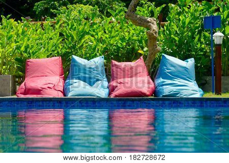 many colorful soft seating to relax near the pool in suuny day. Sport and relax concept.