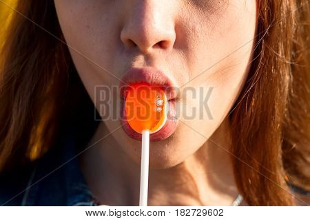 Close-up Of A Girl Sucking A Candy On A Chupa Chups Sticking A Candy With Her Lips