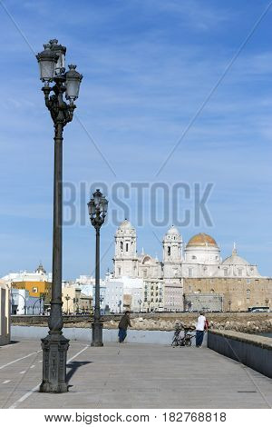 Cadiz SPAIN - March 31: Seafront and rail bicycle to the evening to the fund the cathedral of the holy cross In cadiz Andalusia Spain