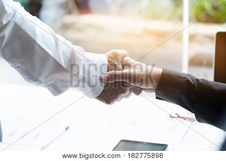 Acquisition conceptHandshake of businessmen on blur businesspeople background vintage tone and greeting dealing merger.