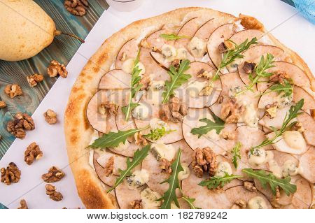 Dessert pizza with a pear and lemon oil, walnut and crude Dorblu