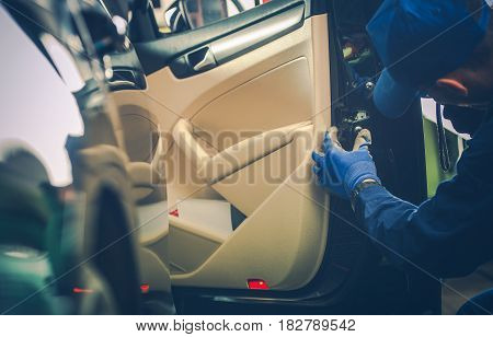 Car Mechanic Trying to Fix Vehicle Door Lock. Automotive Technician Looking at the Central Locking System.