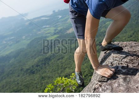 success young woman rock climber on mountain peak