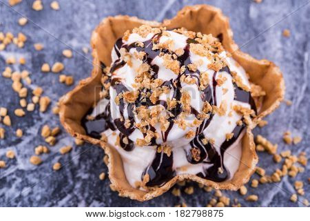 Chocolate ice cream in a basket with shredded nuts