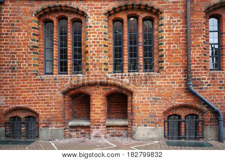 Windows and stone bench in niche of brick wall of Old Town Hall in Hannover, Germany.