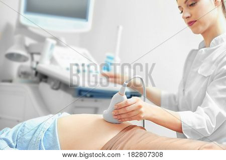 Pregnant woman undergoing ultrasound scan in modern clinic