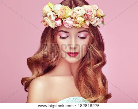 Beautiful blonde woman with flower wreath on her head. Beauty girl with flowers hairstyle. Perfect makeup. Beauty fashion. Spring woman