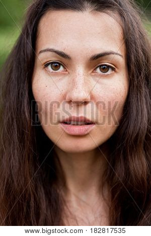 Portrait of a young beautiful brunette with Freckles