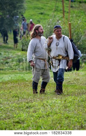 TERVETE LATVIA - AUGUST 13 2011: Historical Zemgalu days. Unknown men in historical dress standing in the meadow and talking.