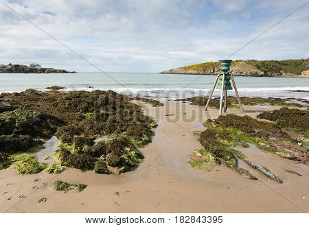 Cemaes bay in Anglesey North Wales at low tide with tidal bell