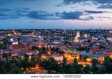 Vilnius, Lithuania. Historic Center Cityscape At Blue Hour After Sunset. Old Town Under Evening Dusk Sky. Travel Panorama In Night Illuminations. UNESCO World Heritage Site. Sts Johns' Church