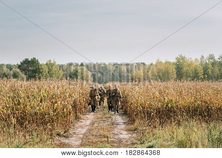Dyatlovichi, Belarus - October 1, 2016: Reenactors Men Dressed As Russian Soviet Red Army Infantry Soldiers Of World War II Marching In Field With Weapon Machine-gun At Historical Reenactment