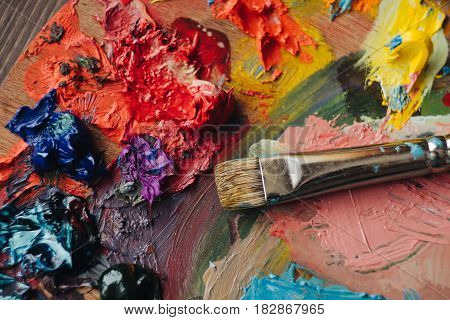 color palette with fresh paint and brush on wood table