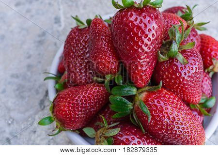 Closed up of fresh strawberry in white dish on marble background