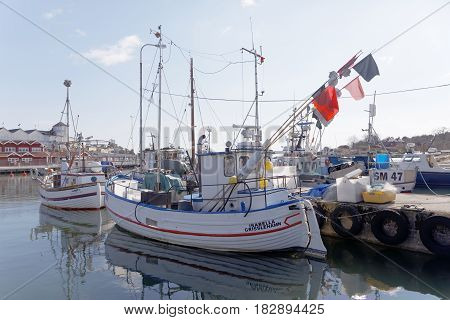 GRISSLEHAMN SWEDEN - APR 15 2017: Fishing boats in the rural harbor. Hotel Havsbaden in the background. April 15 2017 in Stockholm Sweden