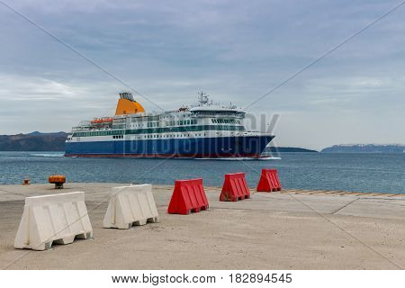 The big sea ferry is moored off in the port of Athinios on the island of Santorini.