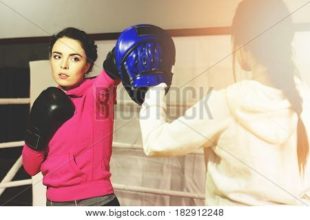 Beautiful Boxing Girl Performs Strong Punch In The Ring. Training At The Gym. Sporty Female Doing Bo