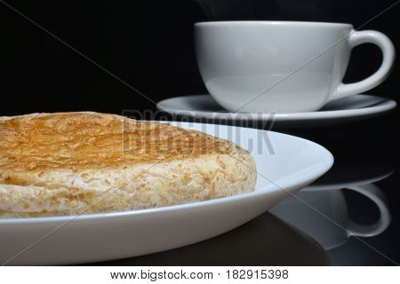 Close-up whole wheat bread on white dish and blur coffee cup.