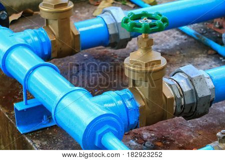 water valve plumbing joint steel tap pipe with green knob close up