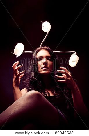 young woman with snakelike lamps behind her head. really scary.