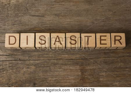 word disaster written on cubes on wooden background
