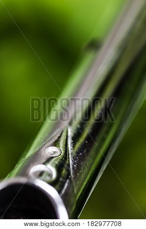 Detail of shiny metal chrome bicycle frame lug and tube on green ecology nature background