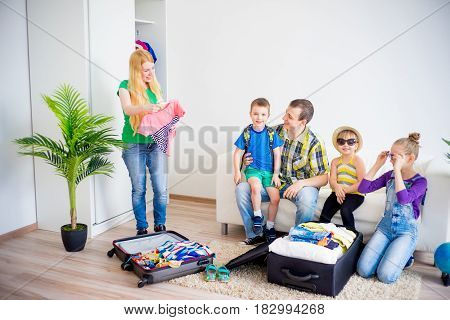 Happy family packing suitcases for a trip holiday travel vacation