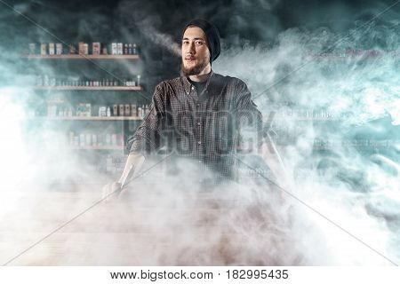 Vape Shop. Man Is Smoking E-cigartte. Cloud Of Vapor.