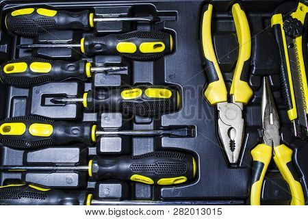 Big Tool Kit Of Black And Yellow Colors For The House In A Box. Flat-nose Pliers, Screw-drivers, Sta