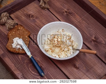 Breakfast Of Milk Rice Porridge And Two Toasts With Cream Cheese On A Wooden Rustic Tray.