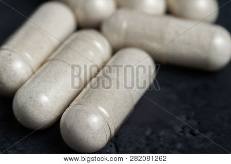 White Medical Capsules Of Glucosamine Chondroitin, Healthy Supplement Pills On A Dark Background, Ma