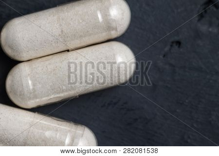 White Medical Capsules Of Glucosamine Chondroitin, Healthy Supplement Pills On A Dark Background, Ma