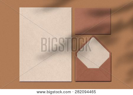 Blank Sheet Of Paper And Letter Against Brown Background. Envelope. Writing Notes Concept. Top View.