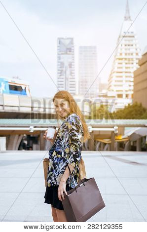 Portrait Of Beautiful Caucasian Woman Smling And Holding Shopping Bags In City,lifestyle Concept