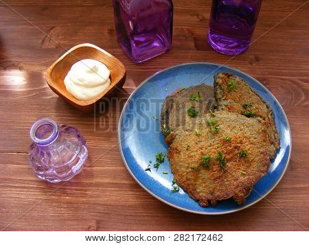 Potato Flapjack (draniki) With Sour Cream And Violet Glass On Wooden Table