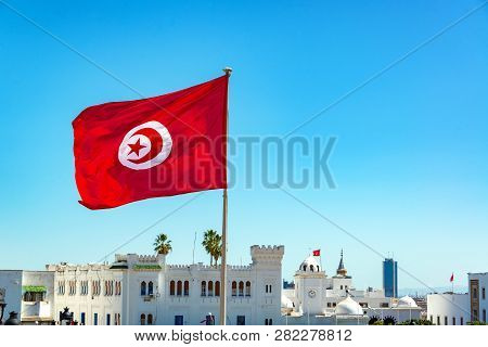 Tunisia Flag Waving In Tunis With Government Buildings In The Background