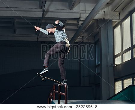 Skateboarder Performing A Trick On Mini Ramp At Skate Park Indoor.
