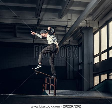 Skateboarder Performing A Trick On Mini Ramp At Skate Park Indoor.