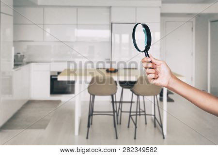 Home inspection - magnifying glass inspector looking at kitchen house background.