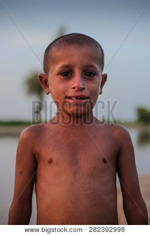 Portrait Of A Nacked Village Boy, Smiling And Looking At Camera In Sindh, Moro, Pakistan 26/08/2017