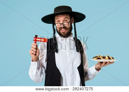 The Young Orthodox Jewish Man With Black Hat With Hamantaschen Cookies For Jewish Festival Of Purim 