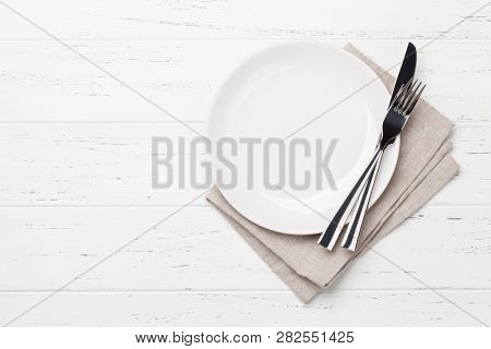 Table setting. Empty plate, knife, fork and napkin. Top view and flat lay with copy space