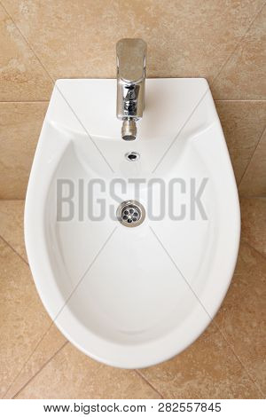 Bidet Is White In The Bathroom, New. Bidet - The Device To Wash