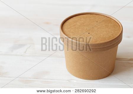 Kraft paper soup bowl with lid on a white table