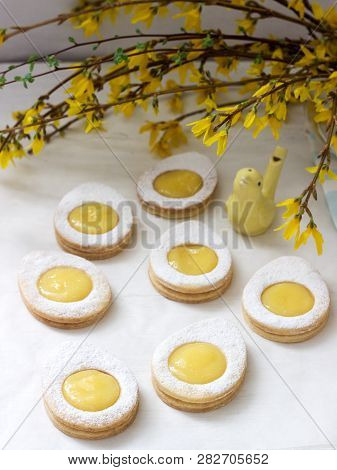 Homemade Easter Lemon Cookies And Forsythia Blooming Twigs On A Light Background.