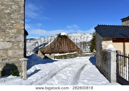 Piornedo, Ancares, Galicia, Spain. Ancient snowy palloza house made with stone and straw. Mountain village, winter and snow.