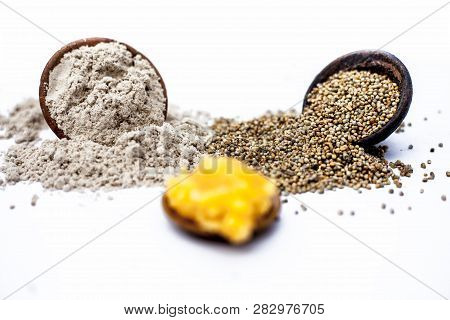 Close Up Of Grain Of Pearl Millet Or Bajra Or Bajri In A Clay Bowl With Its Flour And Jaggery In A S